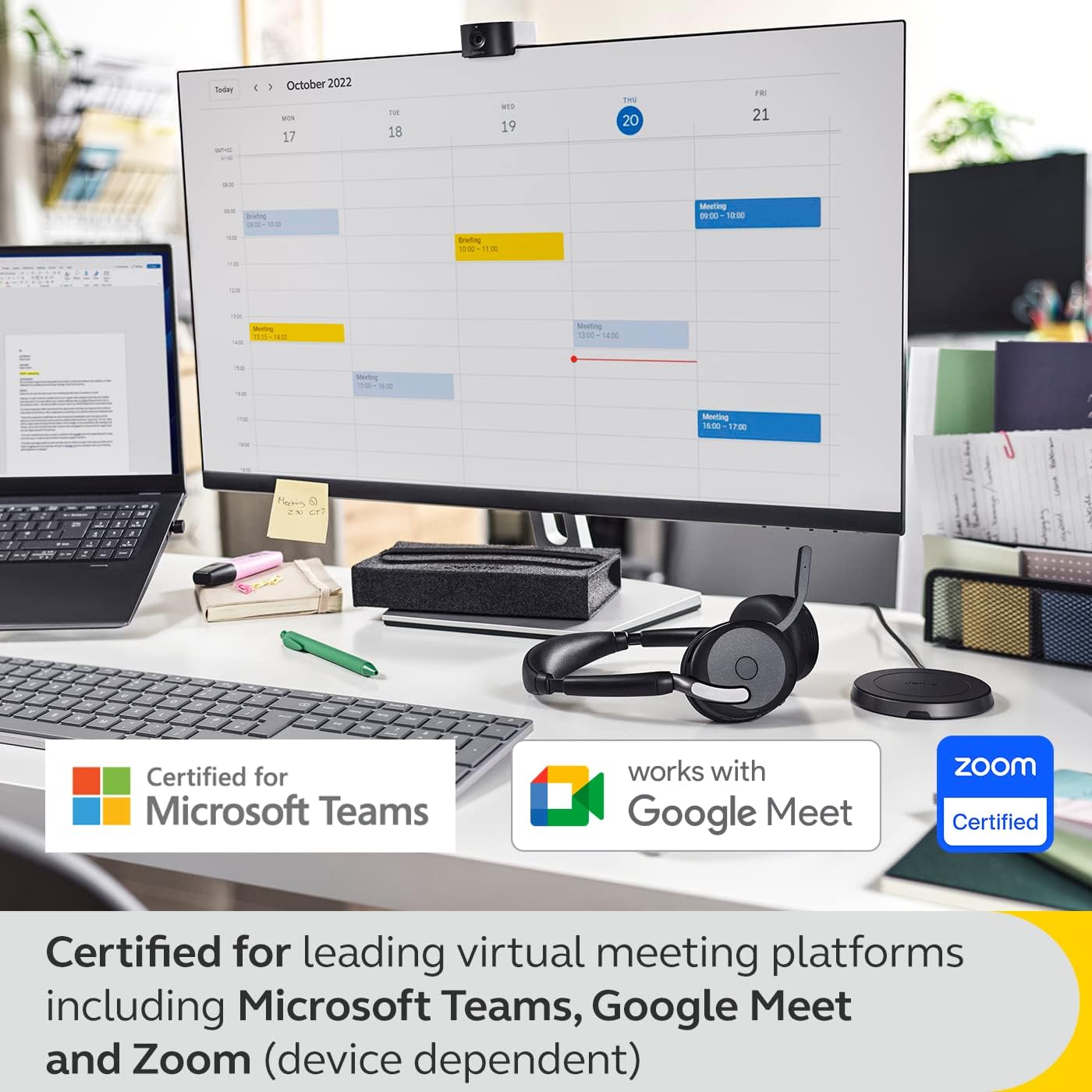 A desk setup features a computer monitor displaying a calendar, a laptop, notebooks, and a pair of JABRA Evolve2 65 Flex Wireless Stereo Headset - Bluetooth, Noise-Cancelling ClearVoice Technology & Hybrid ANC - Works with All Leading UC Platforms Such As Zoom & Google Meet - Black. Various labels indicate certifications for Microsoft Teams, Google Meet, and Zoom. The text at the bottom describes the certifications for virtual meeting platforms.